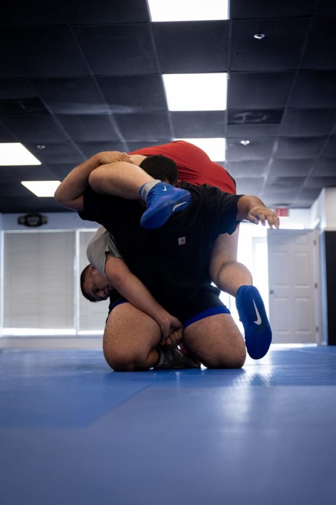Two men wrestling on a blue mat