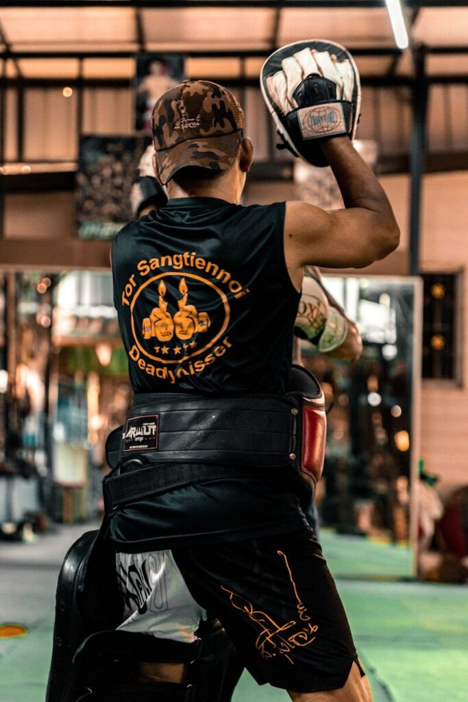 Boxer training with pads in a gym
