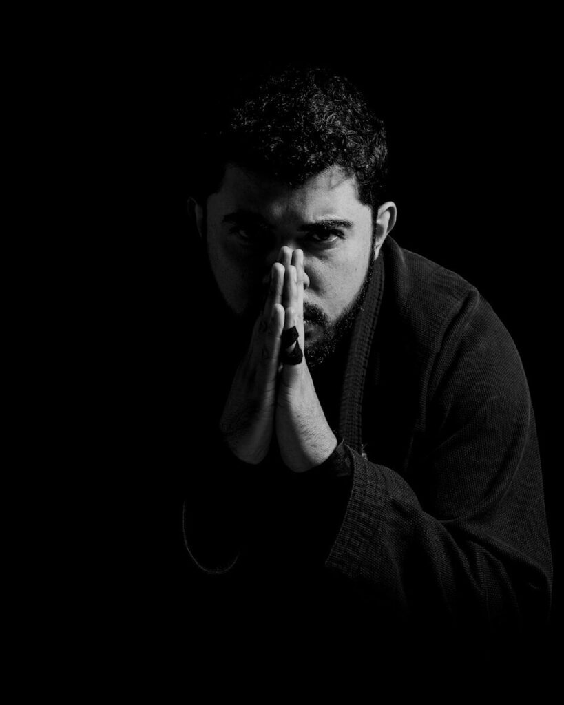 A black and white photo of a man covering his face