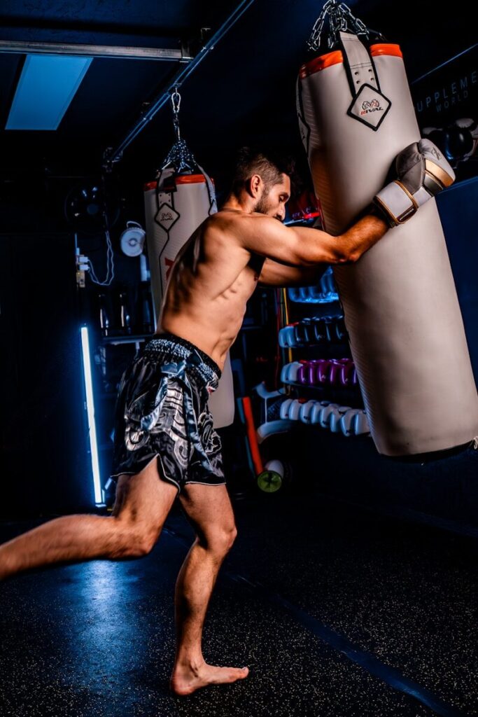 Man punching a heavy bag in a gym.