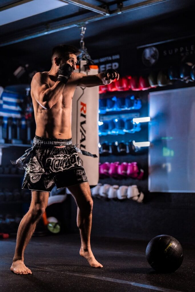 Man training with a punching bag in a gym.