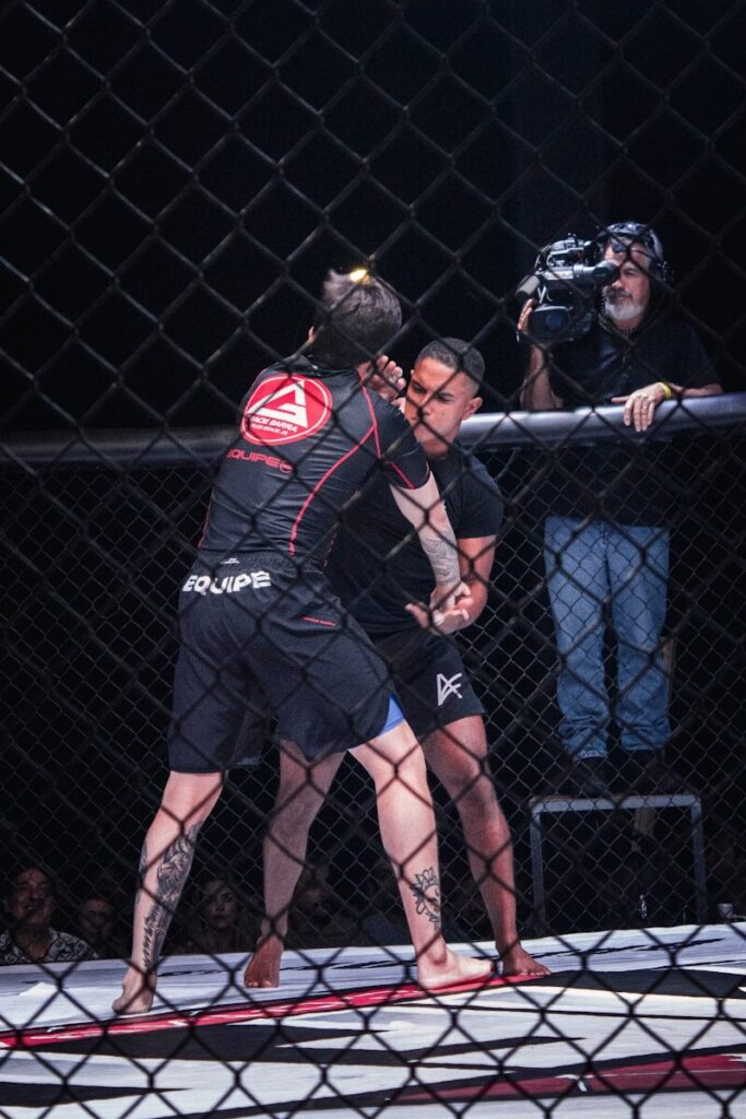 Two fighters grappling inside a cage